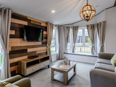 A living room with a television and sofa at Elsham Lodge in Louth