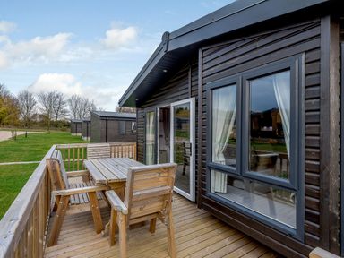 An outdoor seating area with wooden furniture at Elsham Lodge in Louth