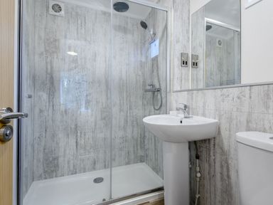 A bathroom with a shower, sink and toilet at Stamford Spa in Louth