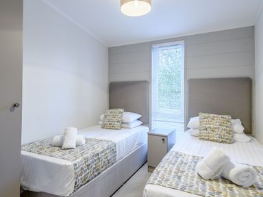 A bedroom with two single beds and a window at Stamford Spa in Louth