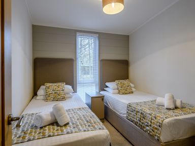 A bedroom with two beds and a nightstand at Stamford Spa (Pet) in Louth