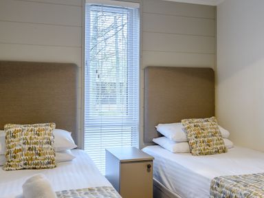 A bedroom with two beds and a nightstand at Stamford Spa (Pet) in Louth