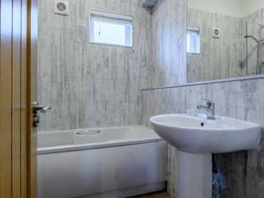 A bathroom with a bathtub and sink at Stamford Spa (Pet) in Louth