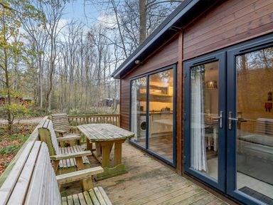 An outdoor seating area with wooden table and benches at Stamford Spa (Pet) in Louth