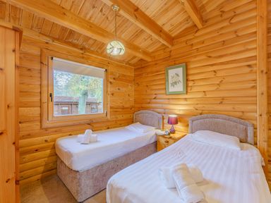 A bedroom with two beds and a window at Cedar Lodge (Pet) in Louth