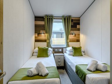 A bedroom with two beds and window at Elsham Lodge (Pet) Louth