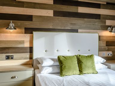 A bedroom with a bed and lamps at Elsham Lodge (Pet) in Louth