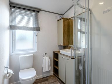 A bathroom with a shower, toilet, and sink at Elsham Lodge (Pet) Louth