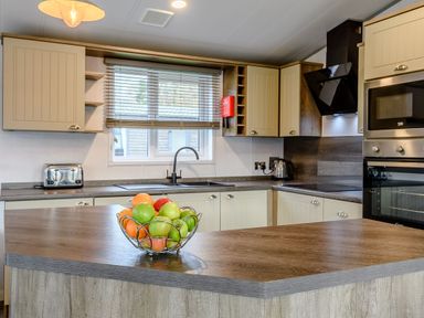 A kitchen with a bowl of fruit and appliances at Elsham Lodge (Pet) Louth