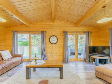A living room with a sofa, coffee table, and television at Hazel Lodge in Louth