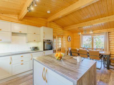 A kitchen with cabinets, countertop, and dining area at Hazel Lodge in Louth