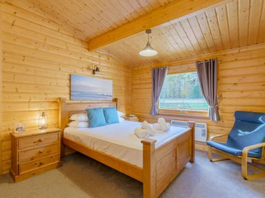 A bedroom with a bed and a chair at Hazel Lodge in Louth