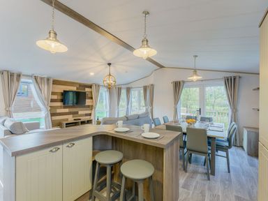 A living room with a sofa, dining area and television at Brayford Lodge in Louth