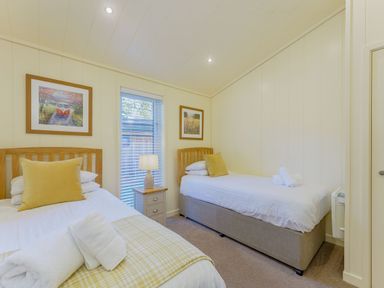 A bedroom with two beds and a lamp at Retreat Lodge 4 in Louth