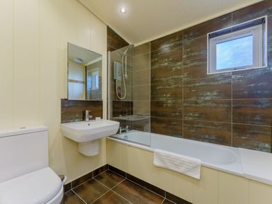 A bathroom with a toilet, sink, shower, and bathtub at Retreat Lodge 4 in Louth