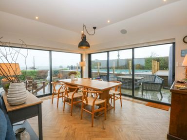 A dining area with a table and chairs at Bryn Mor Cottage in Mynytho near Llanbedrog