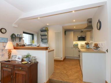 A kitchen with cabinets and appliances at Bryn Mor Cottage, Mynytho near Llanbedrog