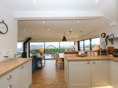A kitchen with a view of the garden at Bryn Mor Cottage Mynytho near Llanbedrog