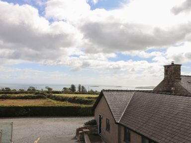 A view of the sea and fields from a cottage at Bryn Mor Cottage in Mynytho near Llanbedrog