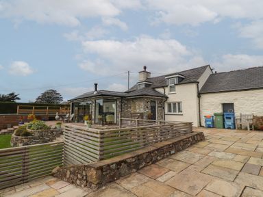 A house with a patio and garden at Bryn Mor Cottage in Mynytho near Llanbedrog