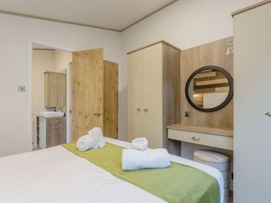 A bedroom with a bed and mirror at Brayford Lodge Spa in Louth