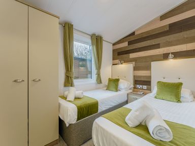 A bedroom with two beds and a wardrobe at Brayford Lodge Spa (Pet) in Louth