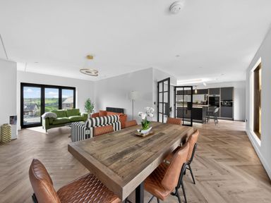 A living room with a dining table and chairs at Heddfan in Carmarthen