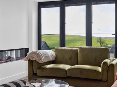 A living room with a sofa and a fireplace at Heddfan in Carmarthen