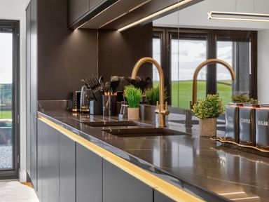 A kitchen with a sink and counter containing utensils and canisters at Heddfan in Carmarthen
