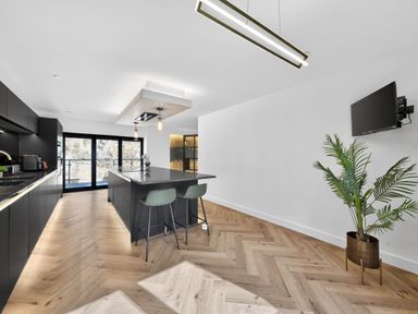 A kitchen with an island and bar stools at Heddfan in Carmarthen
