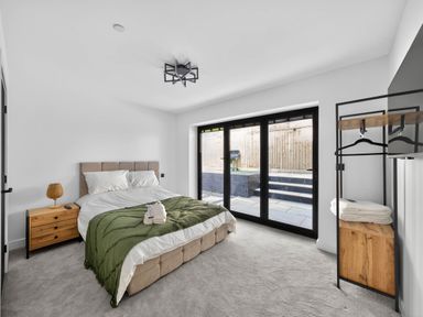 A bedroom with a bed and sliding glass doors at Heddfan in Carmarthen