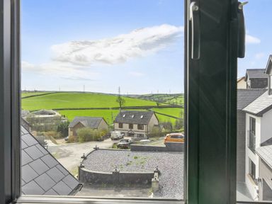 A view from a window showing countryside with houses and a road at Heddfan in Carmarthen