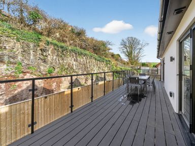 An outdoor deck with a table and chairs at Heddfan in Carmarthen