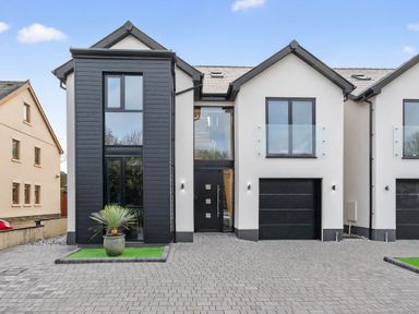 A modern house with a garage and large windows at Ty Uchel 