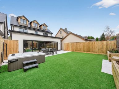 A garden with a hot tub and dining set at Ty Uchel in 