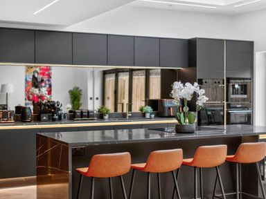 A kitchen with an island and stools at Ty Uchel