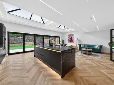 A kitchen with a large island and sliding doors at Ty Uchel