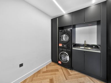 A laundry room with a washing machine, dryer, and sink at Ty Uchel