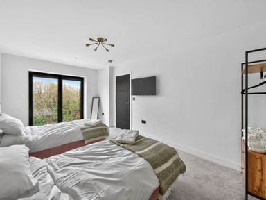A bedroom with two beds and a television at Ty Uchel