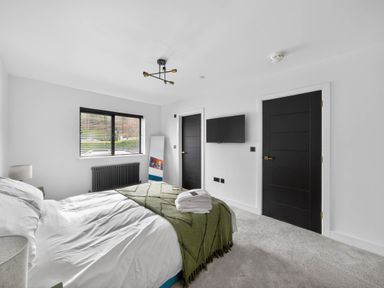 A bedroom with a bed and television at Ty Uchel 
