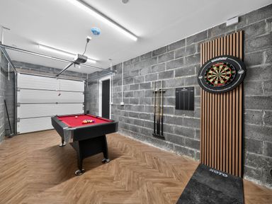 A game room with a pool table and dartboard at Ty Uchel