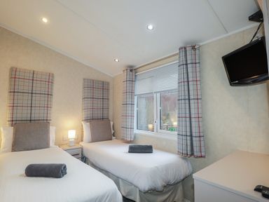 A bedroom with twin beds and a television at Monach 1 