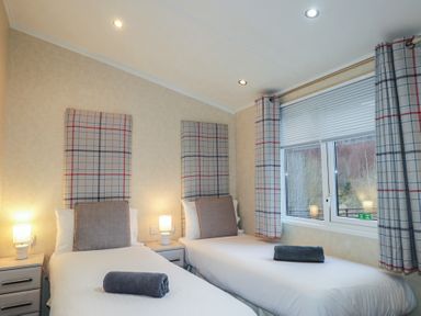 A bedroom with two single beds and a window at Monach 1