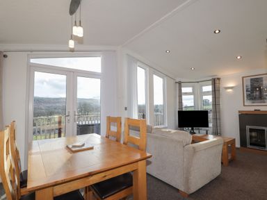 A dining room with a table and chairs and a sofa at Colonsay
