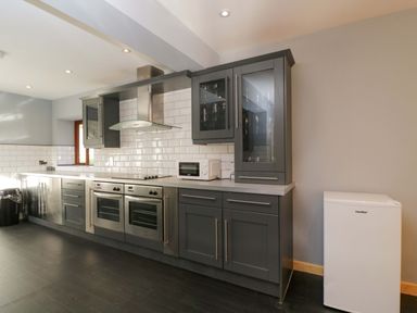 A kitchen with cabinets, stove, microwave, sink, and refrigerator at Lady Of Lourdes in Whitchurch, Herefordshire