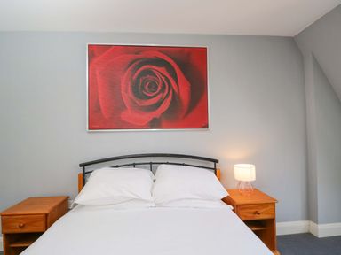 A bedroom with a bed and nightstands at Lady Of Lourdes, Whitchurch, Herefordshire