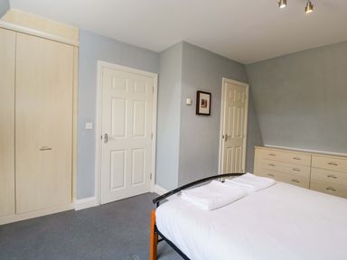 A bedroom with a bed and wardrobe at Lady Of Lourdes in Whitchurch, Herefordshire