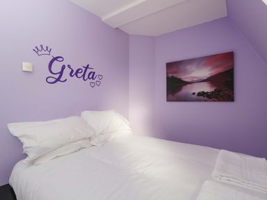 A bedroom with a bed and wall art at Lady Of Lourdes, Whitchurch, Herefordshire