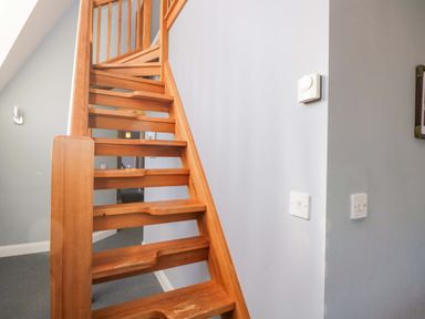 A staircase with a wooden handrail at Lady Of Lourdes in Whitchurch, Herefordshire