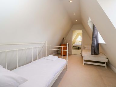 A bedroom with two beds and a nightstand at Lady Of Lourdes in Whitchurch, Herefordshire